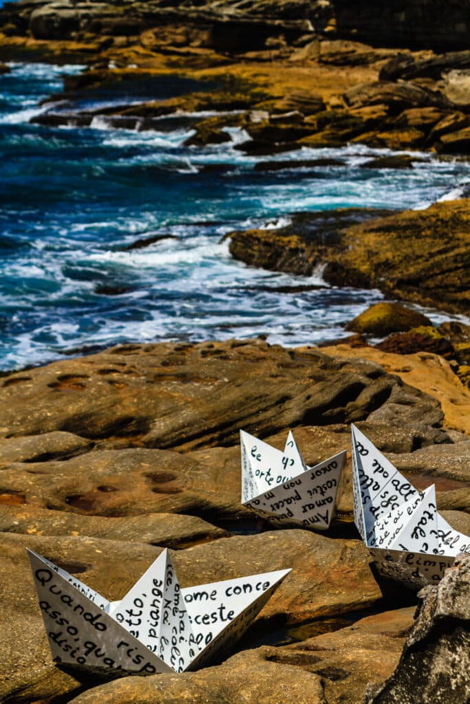 Papierschiffchen auf Felsen an der Küste